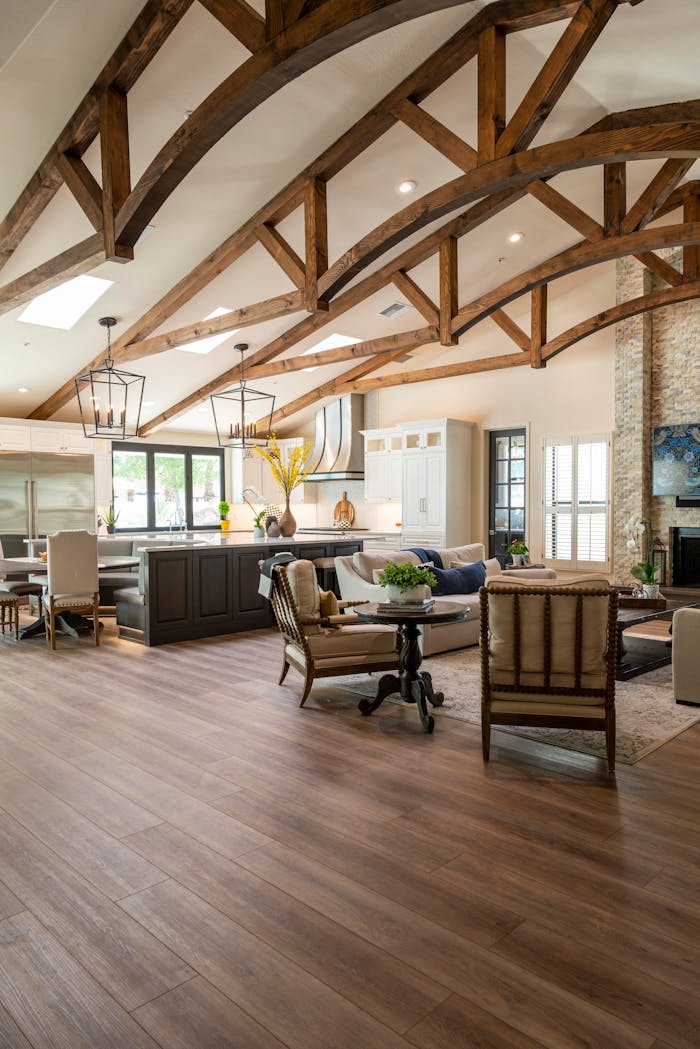 Bright and spacious open-plan interior combining kitchen and living room with wooden beams and modern furnishings.